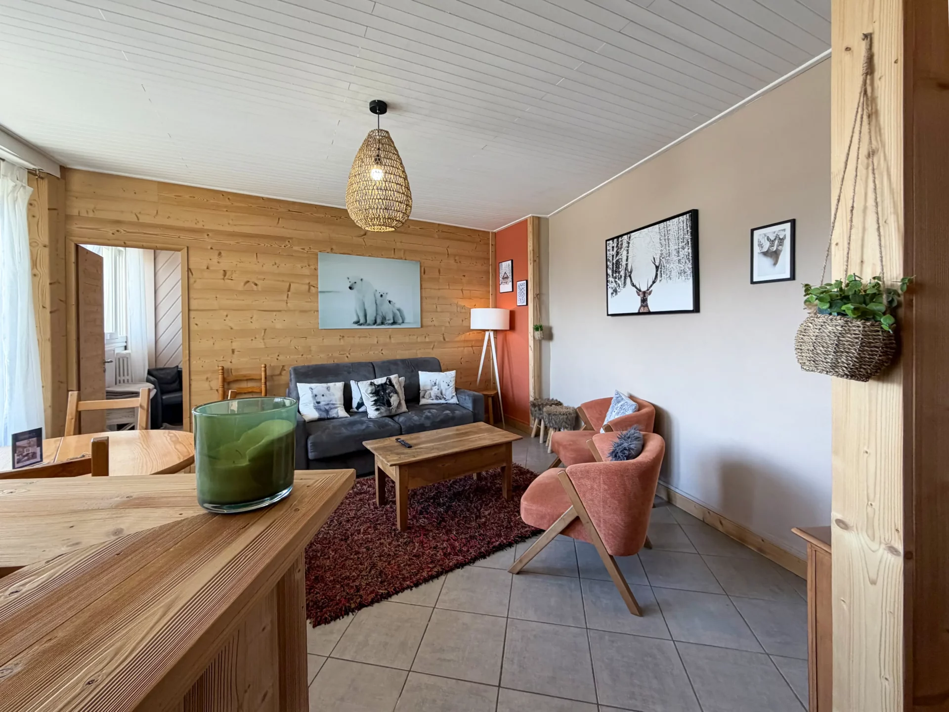 Salon avec fauteuil et canapé. Bar américain au 1er plan