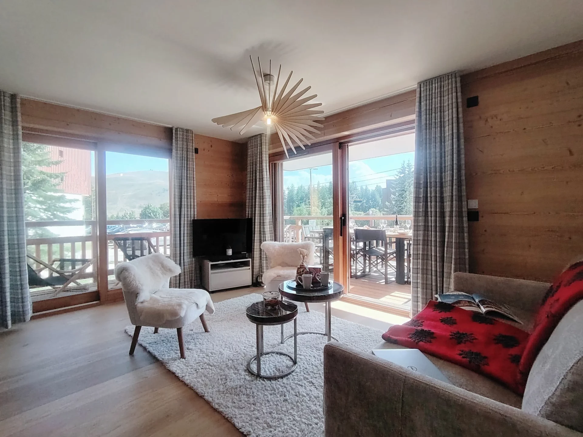 Séjour lumineux de l’appartement A105 Résidence Cachemire à l’Alpe d’Huez, ouvert sur un grand balcon aménagé.