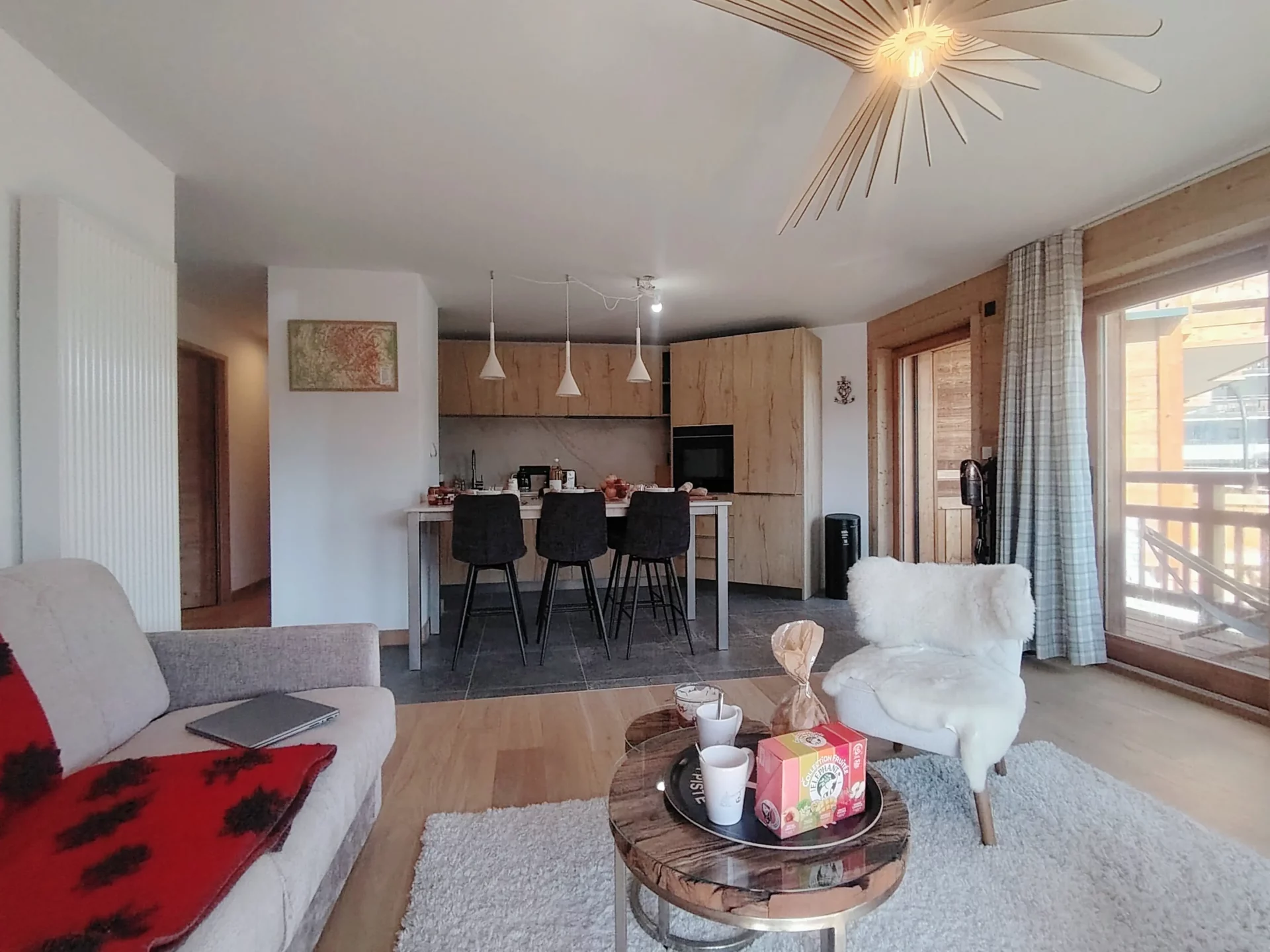 Pièce de vie conviviale avec cuisine ouverte moderne et espace repas, appartement A105 Résidence Cachemire à l’Alpe d’Huez.