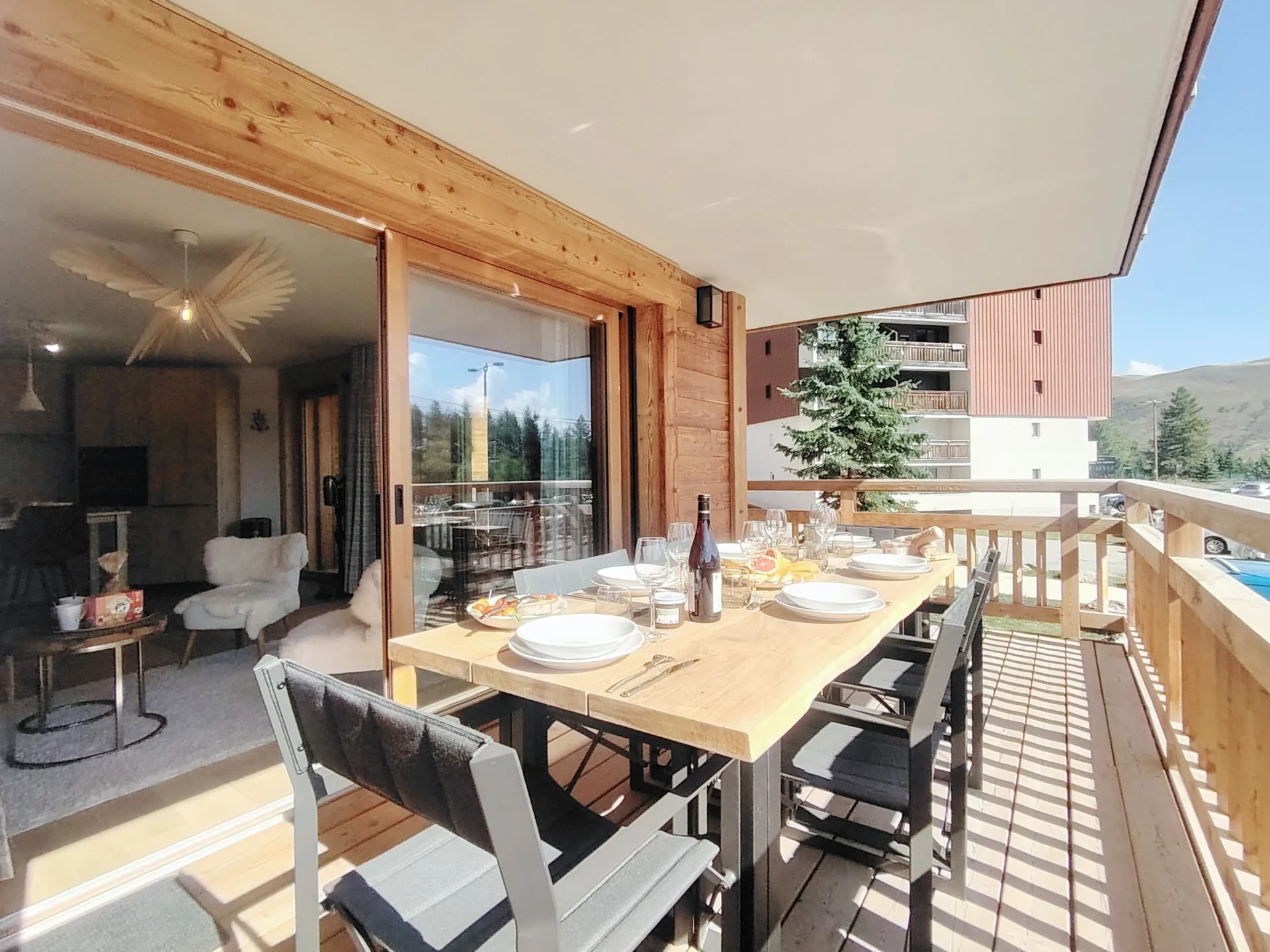 Terrasse aménagée avec grande table à manger donnant sur le séjour – Résidence Cachemire A105 Alpe d’Huez