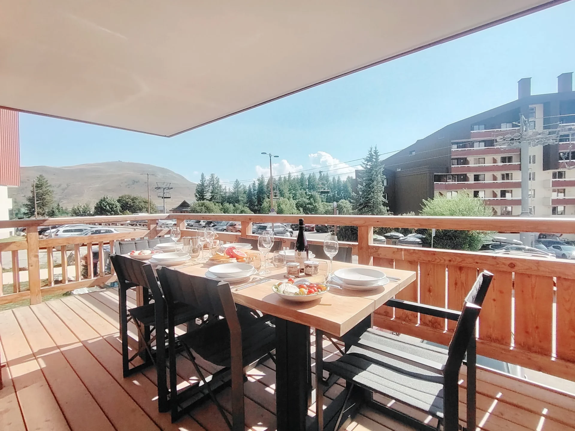 Terrasse ensoleillée avec table dressée et vue dégagée sur la station – Appartement A105 Cachemire