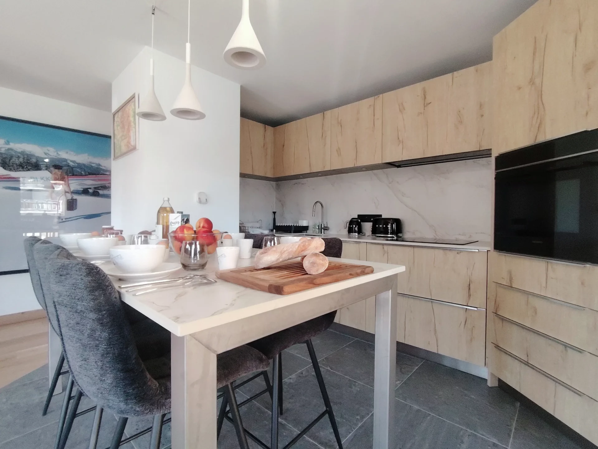 Cuisine moderne entièrement équipée avec plaques induction, four et coin repas – Résidence Cachemire A105 Alpe d’Huez.