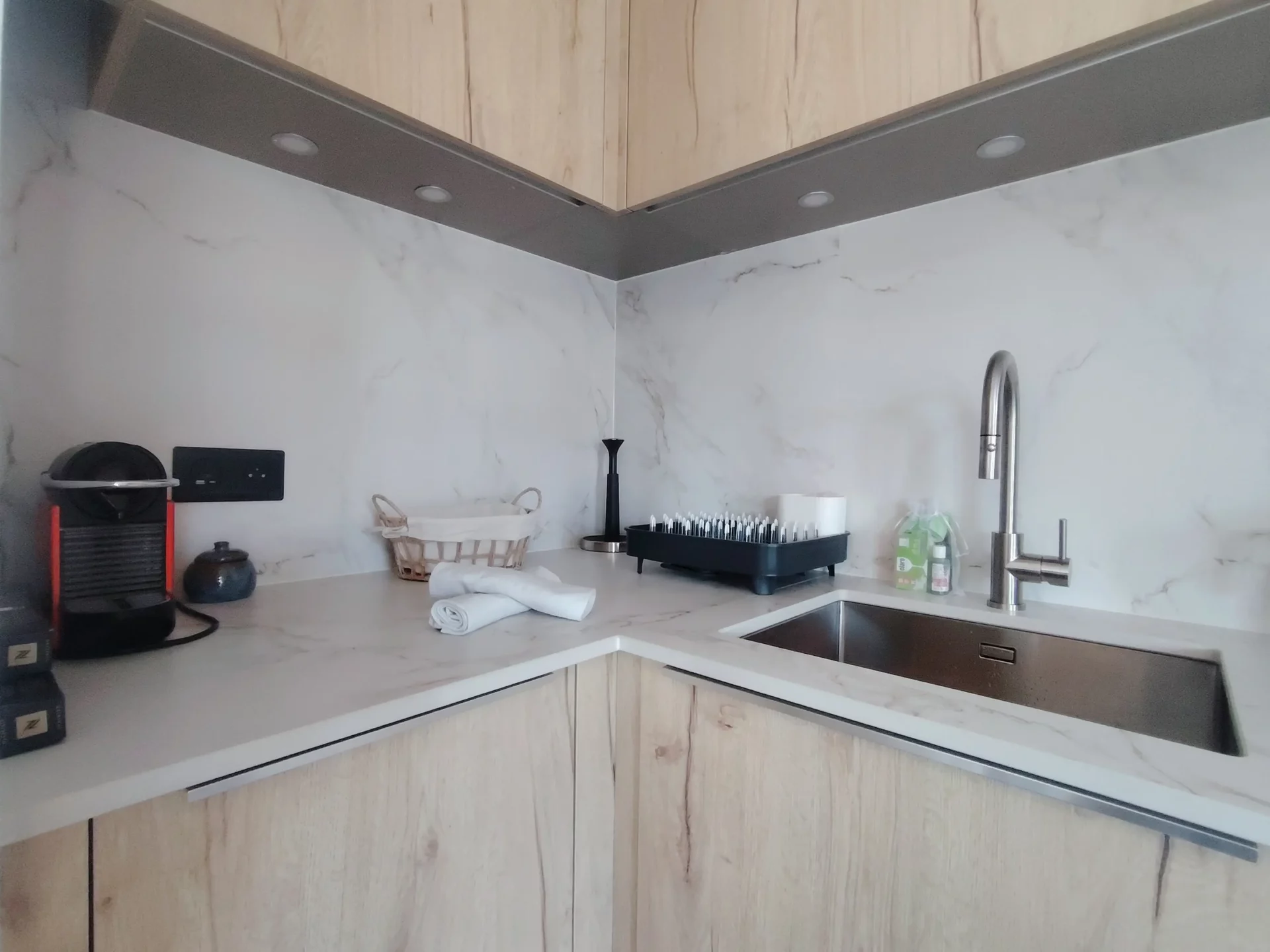 Coin cuisine design avec évier inox, plan de travail marbré et machine Nespresso – Cachemire A105