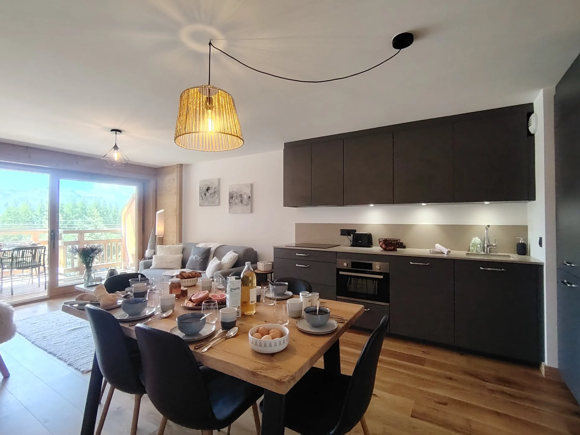 Location appartement à l'alpe d'huez avec un salon, fauteuil, télévision et cuisine en arrière plan