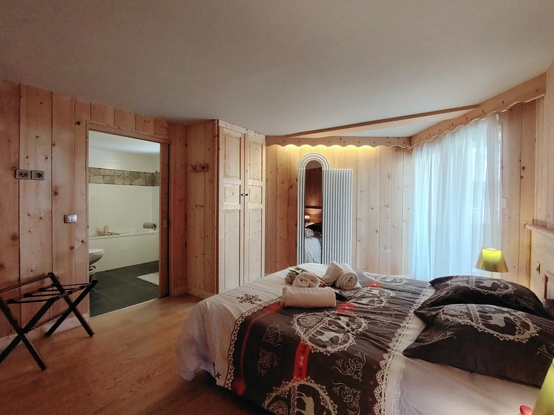 Suite parentale de l’appartement Les Alpages à l’Alpe d’Huez avec lit double, placards intégrés et accès direct à la salle de bain.