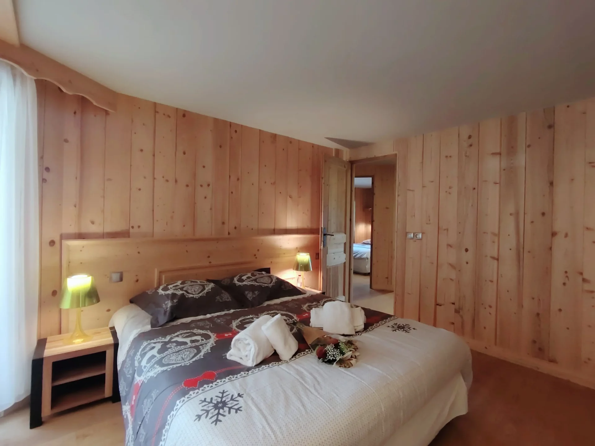 Chambre spacieuse et cosy de l’appartement Les Alpages à l’Alpe d’Huez, décor alpin en bois et lit double accueillant