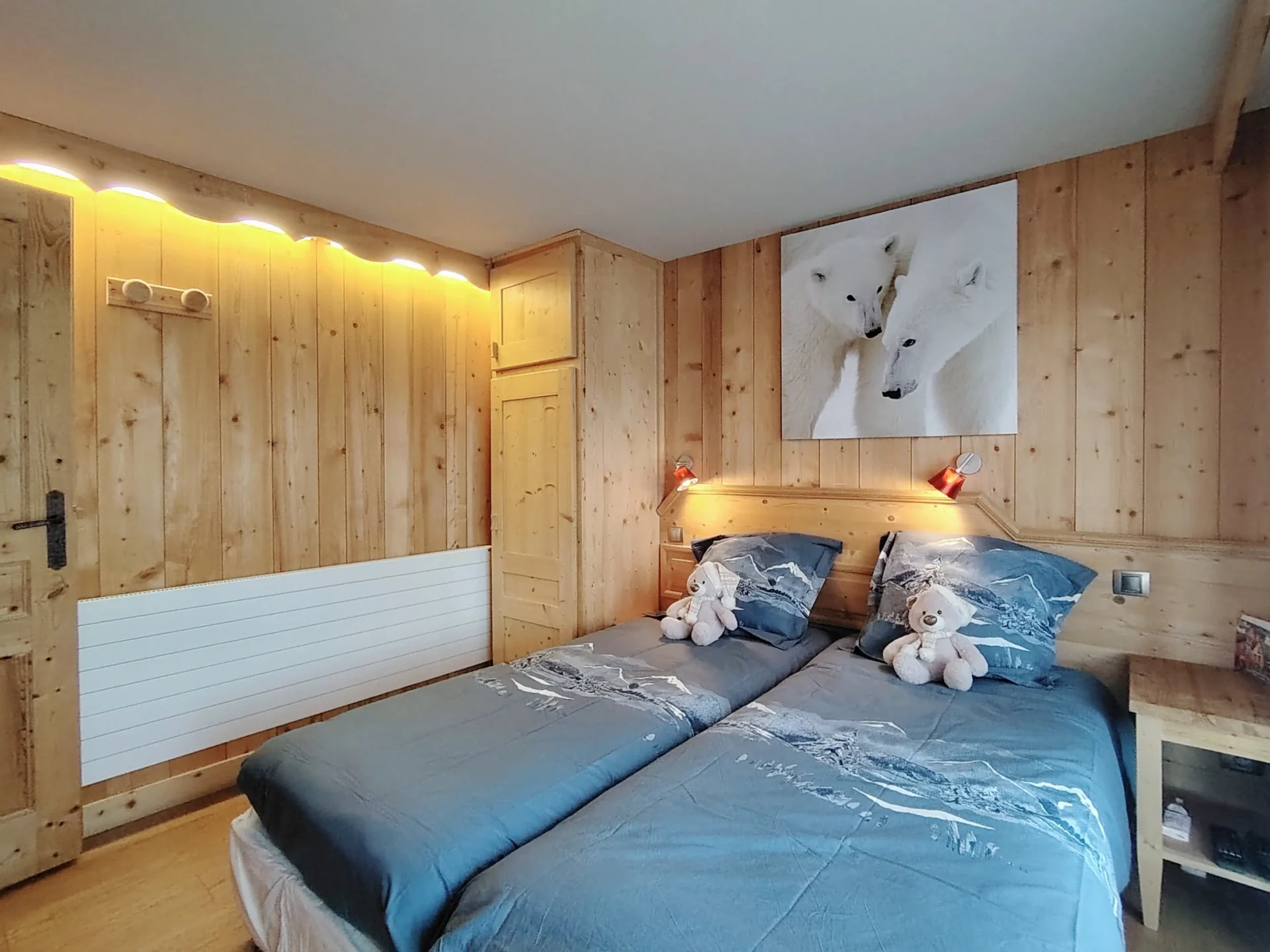 Chambre familiale de l’appartement Les Alpages à l’Alpe d’Huez, deux lits simples confortables et décoration montagnarde