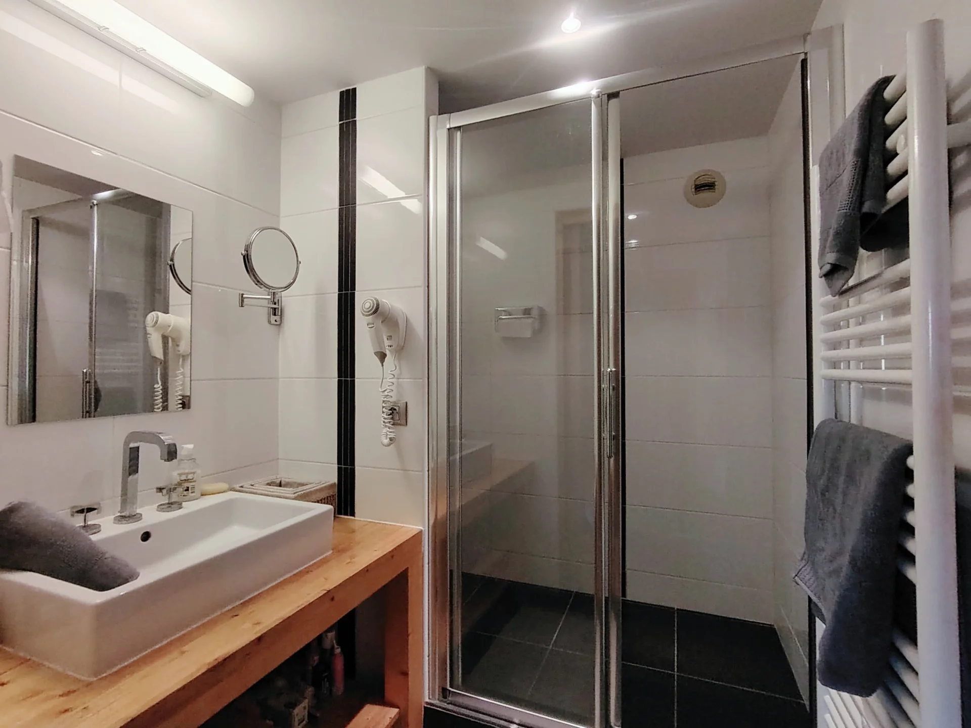 Salle de bain moderne avec douche de l’appartement Les Alpages à l’Alpe d’Huez, équipée d’une vasque et sèche-serviettes