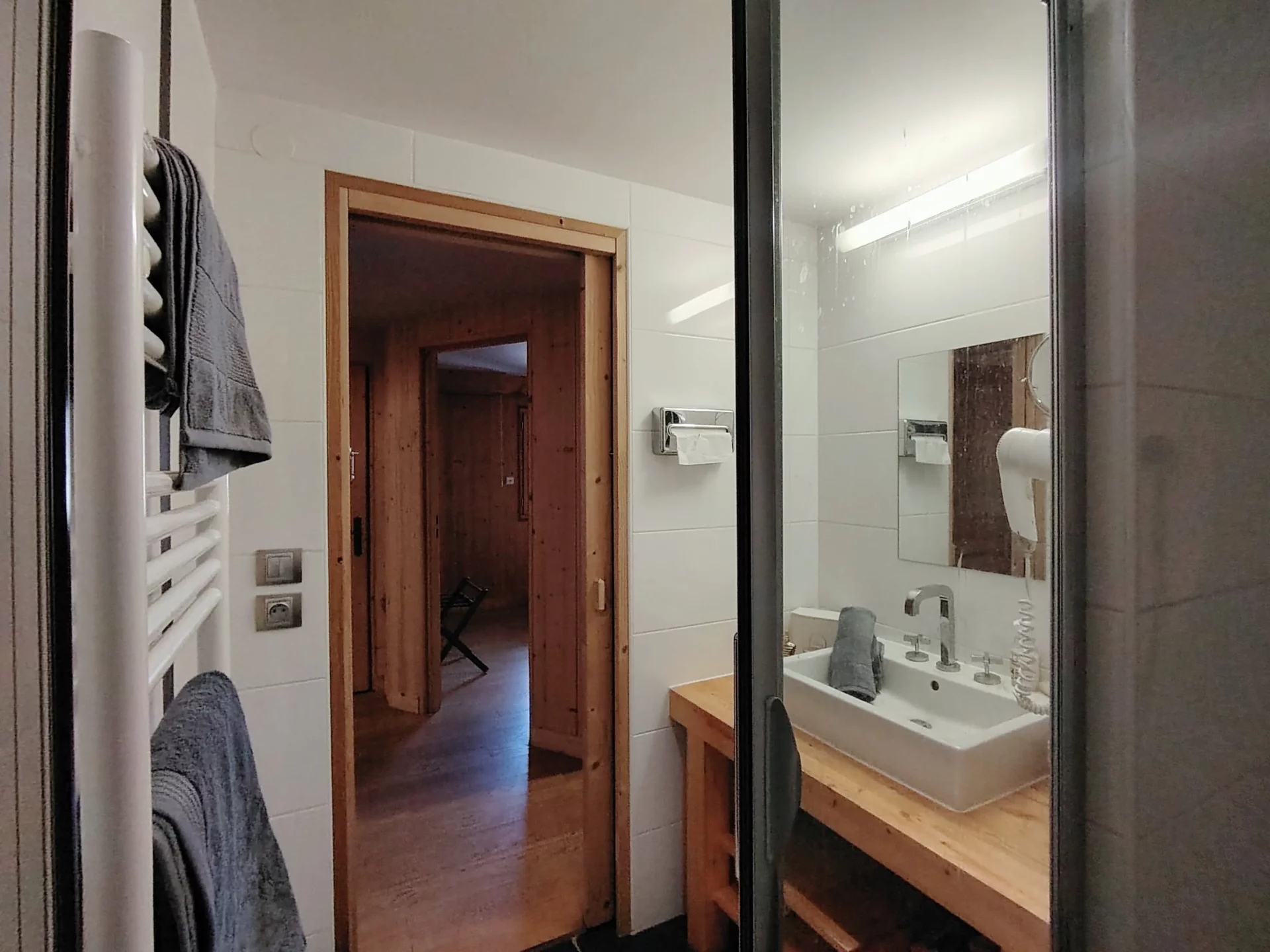 Salle d’eau pratique de l’appartement Les Alpages à l’Alpe d’Huez, accès direct au couloir et ambiance chalet en bois