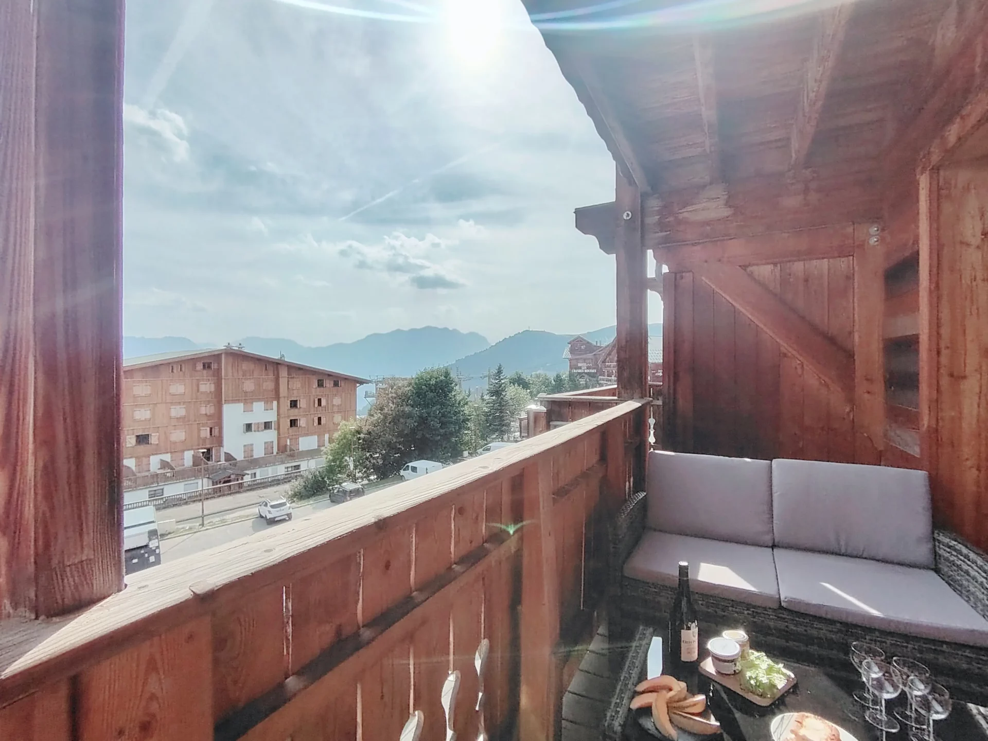Terrasse ensoleillée de l’appartement Les Alpages à l’Alpe d’Huez, aménagée avec salon de jardin et vue panoramique
