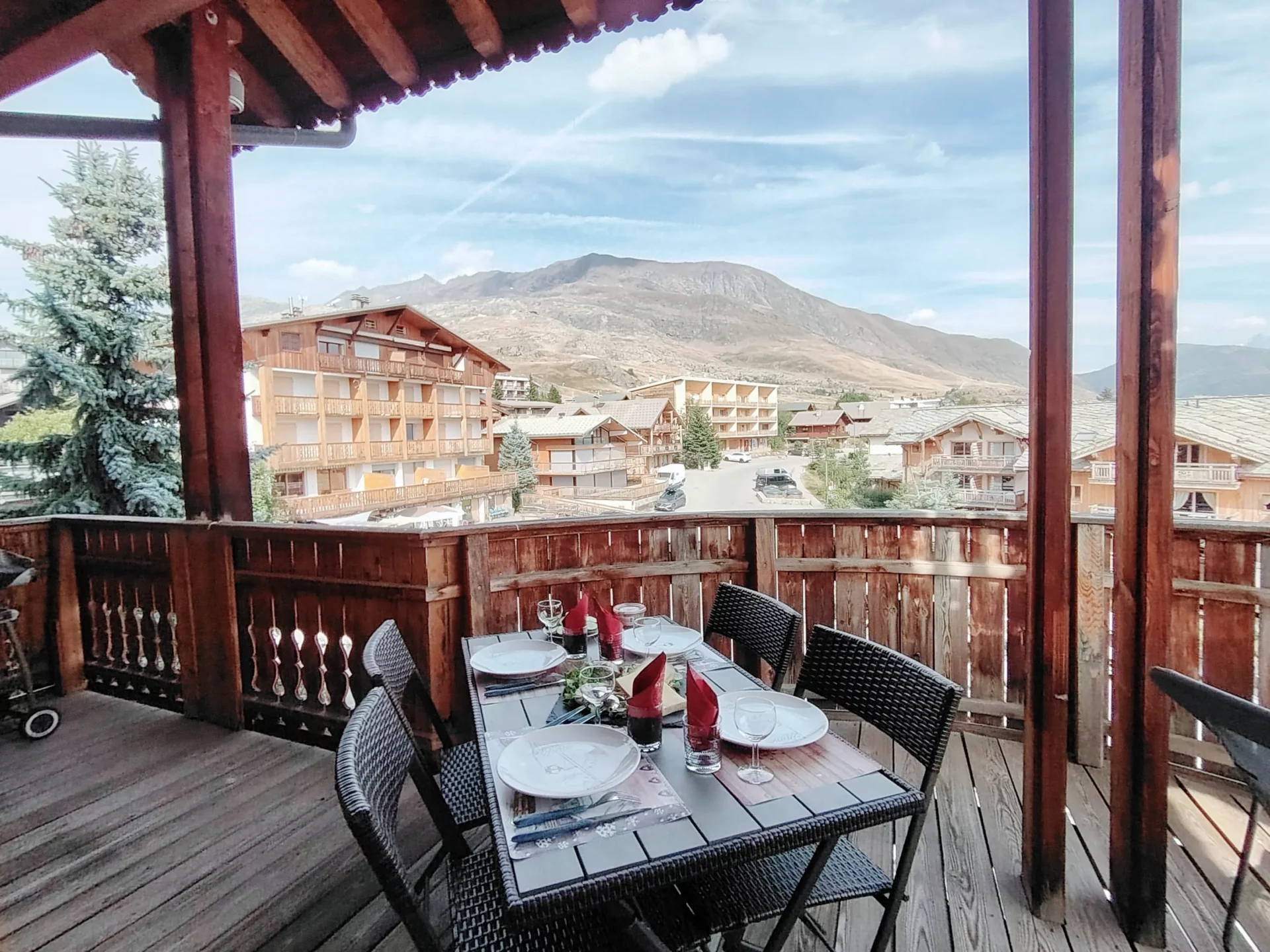 Terrasse panoramique de l’appartement Les Alpages à l’Alpe d’Huez, aménagée pour vos repas face aux sommets alpins
