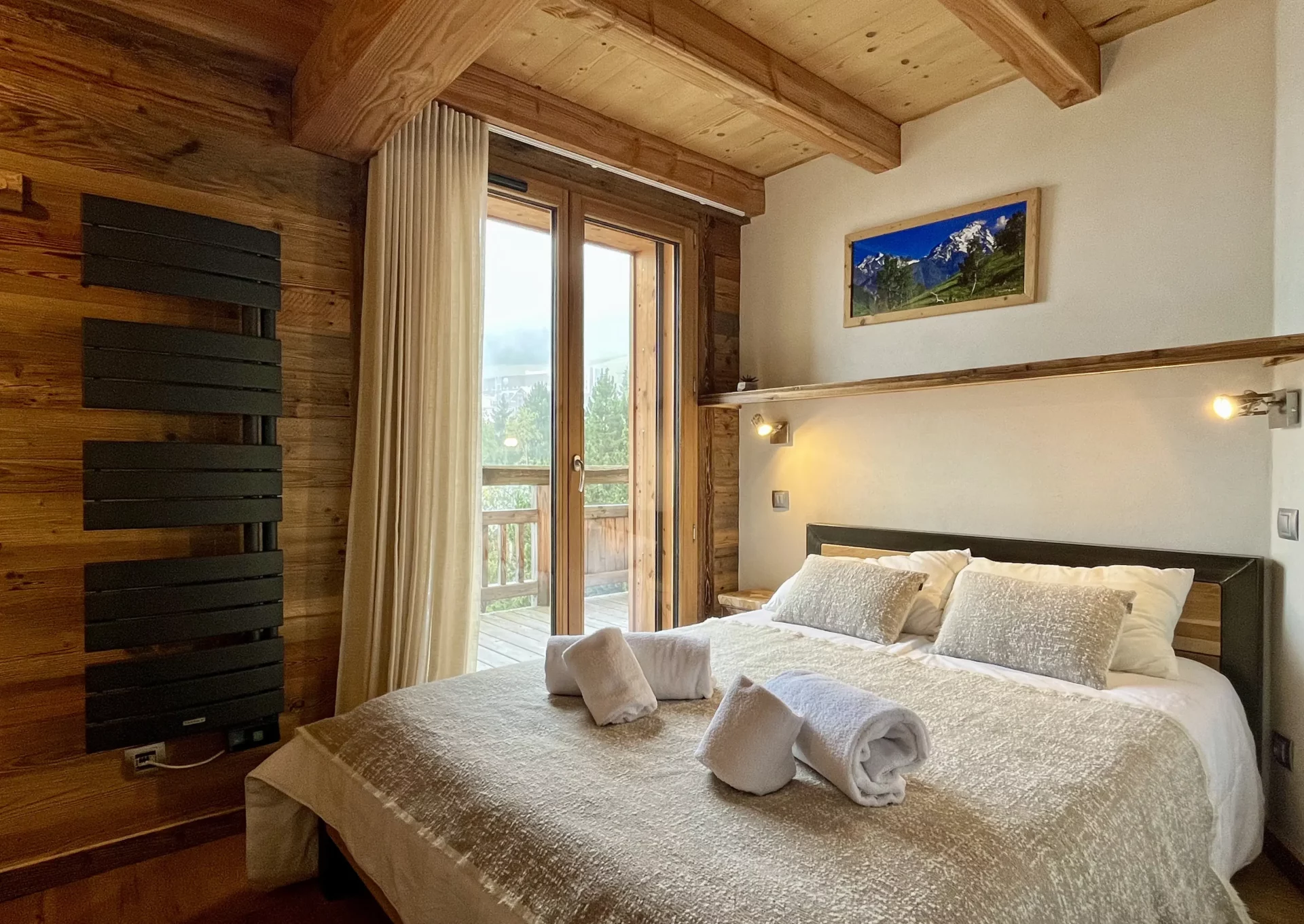 Salon lumineux avec canapés, poutres apparentes et télévision – Résidence Ourson 302 Alpe d’Huez