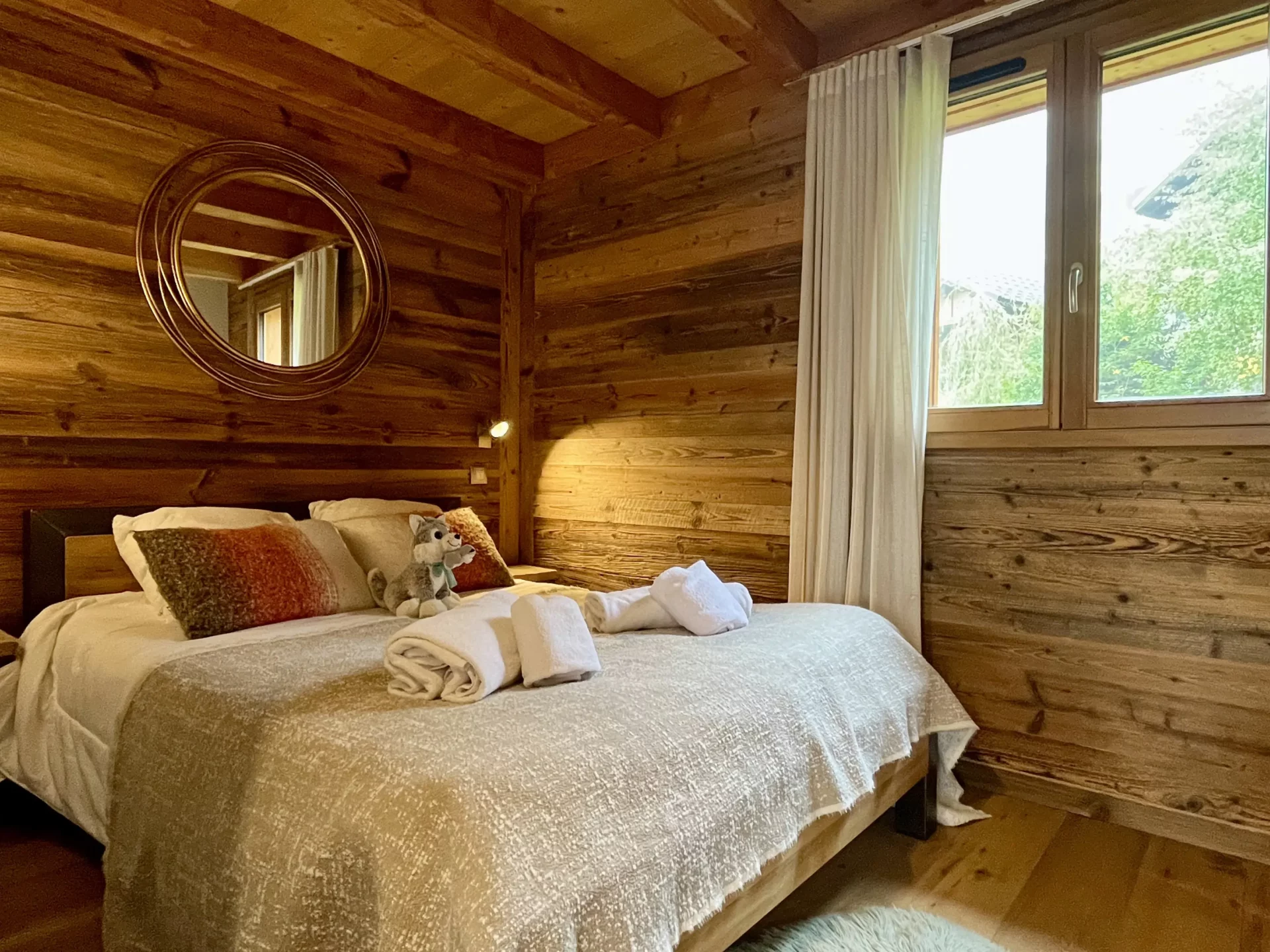 Chambre double chaleureuse avec grandes fenêtres – appartement duplex Ourson 302 Alpe d’Huez