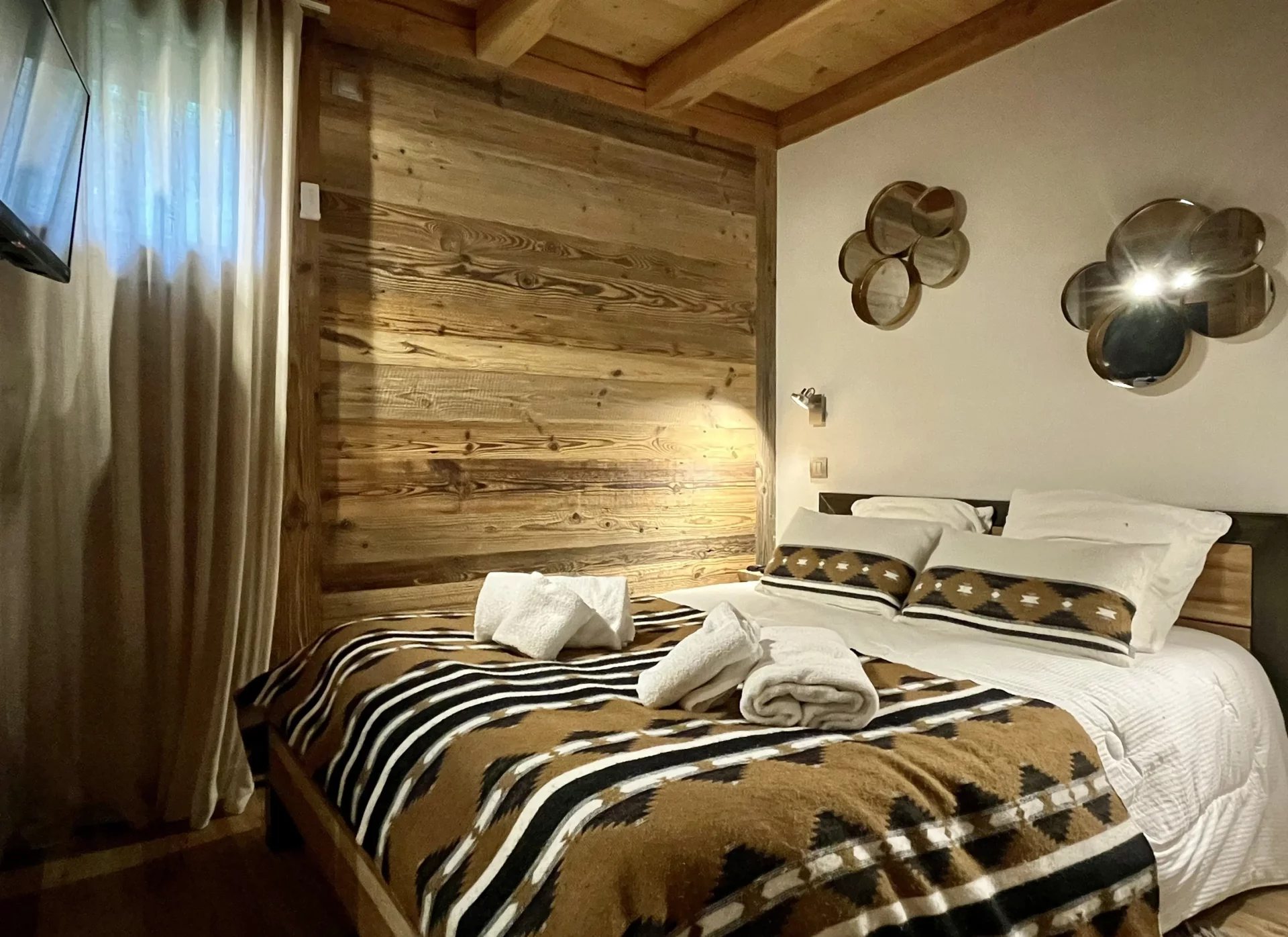 Chambre avec lit double et décoration moderne, ambiance cocooning.