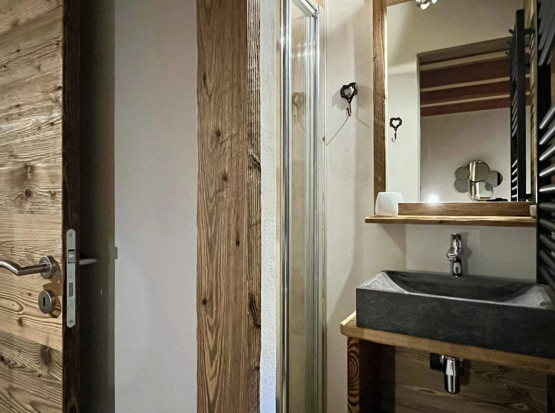 Salle de bain moderne avec douche à l’italienne et vasque en pierre.