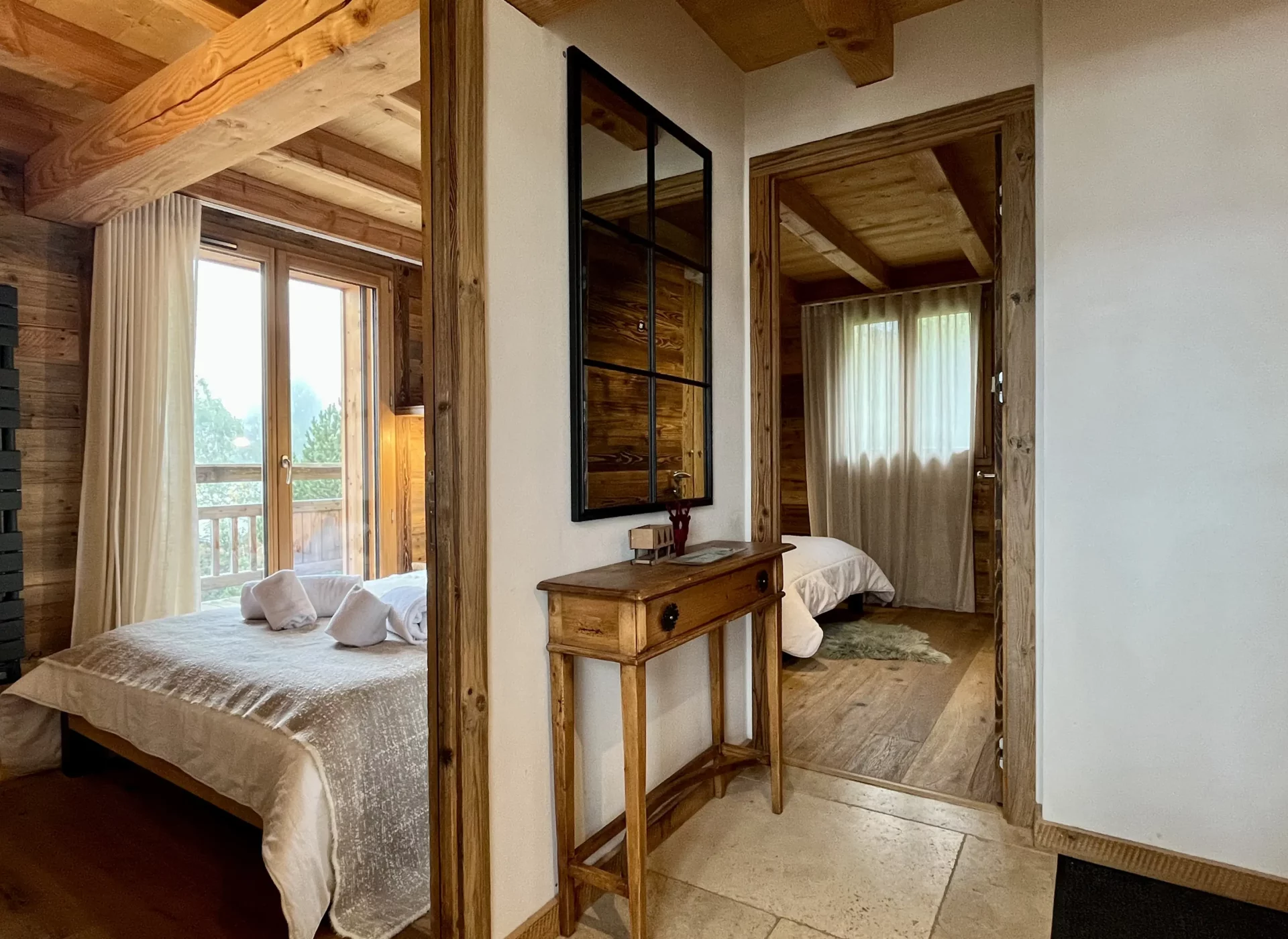 Couloir décoré avec affiches vintage de l’Alpe d’Huez et mobilier en bois.