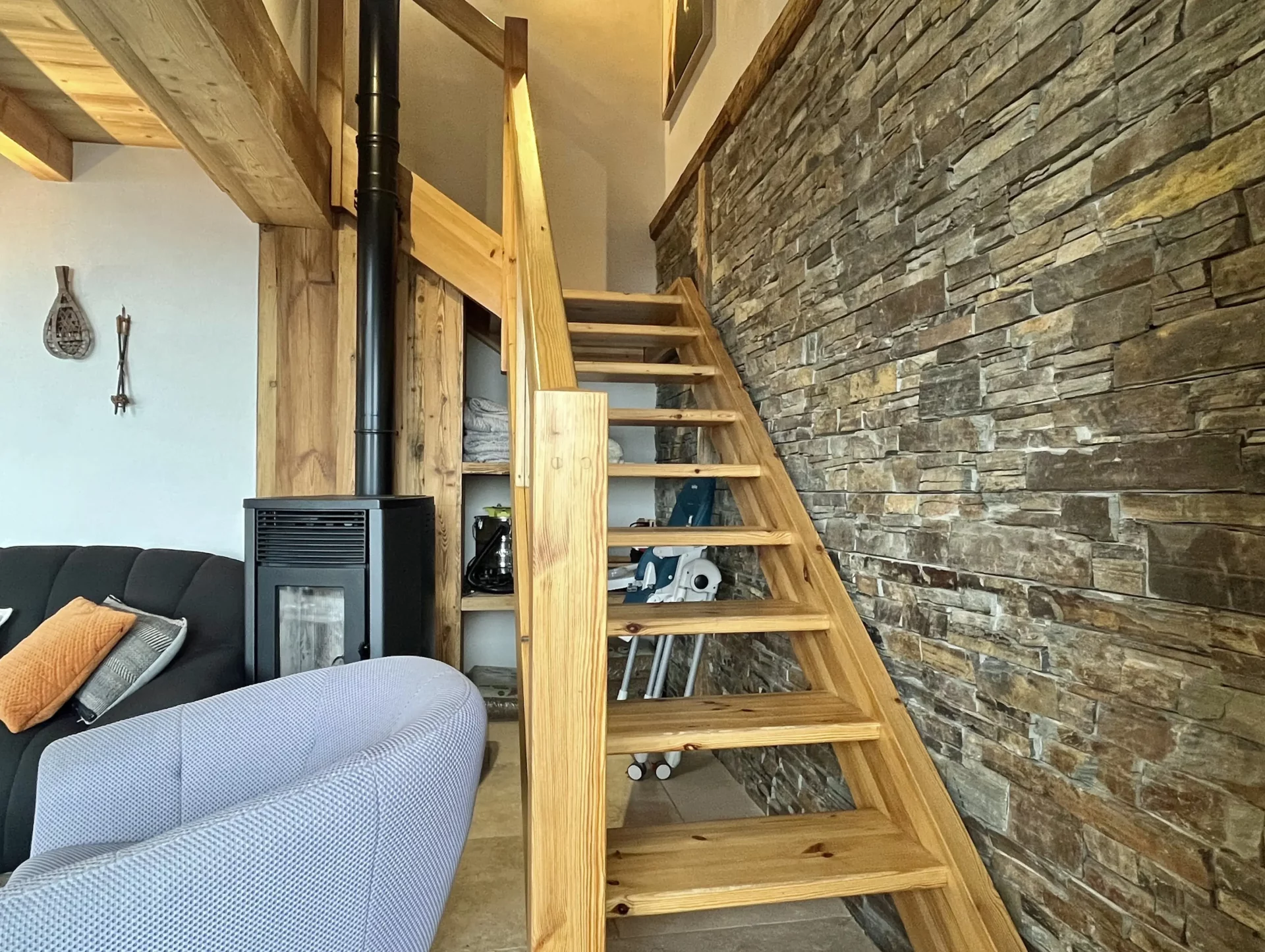 Escalier en bois et mur en pierres naturelles dans un appartement de montagne.