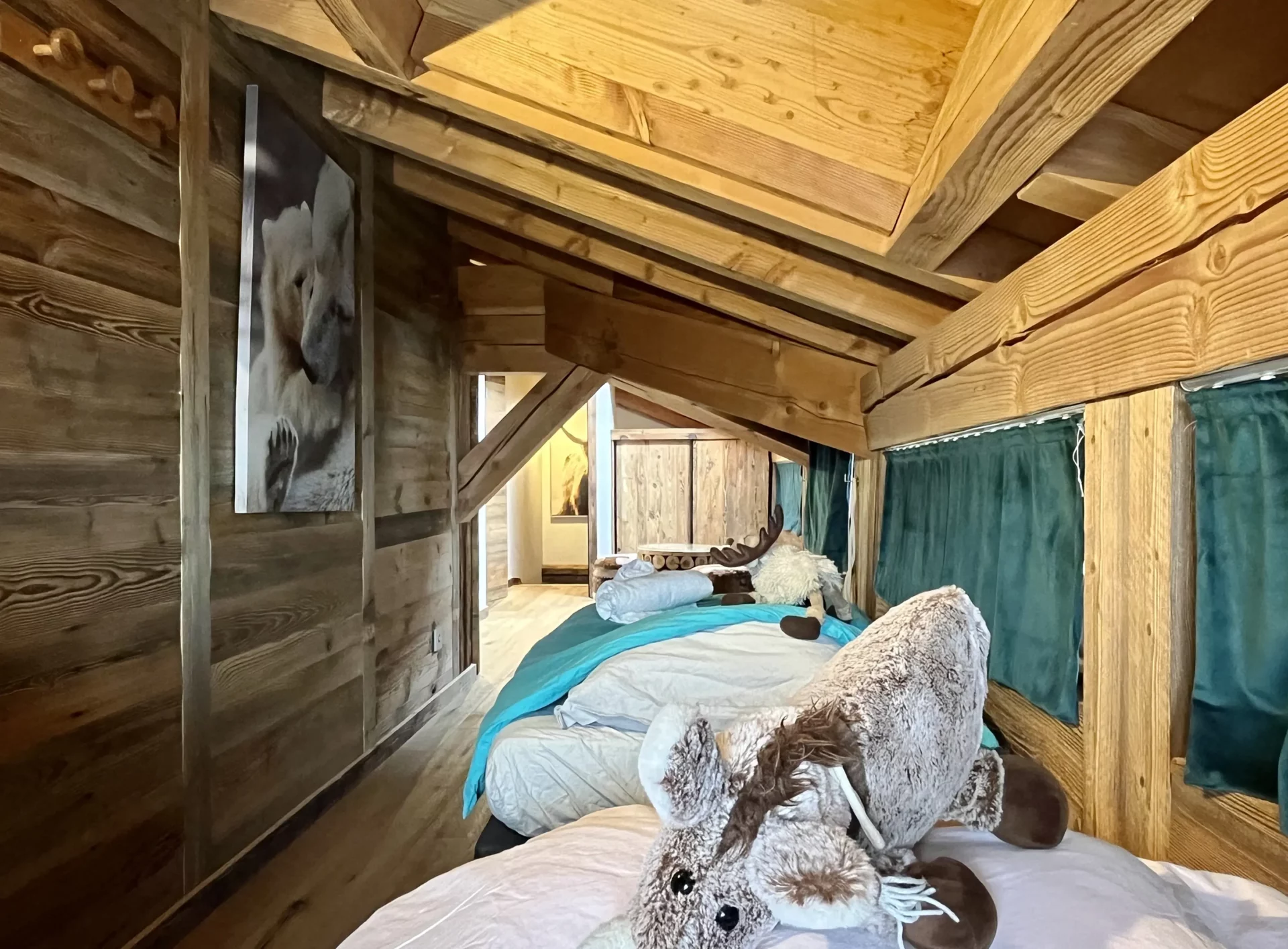 Mezzanine aménagée en dortoir avec lits simples et ambiance montagne.