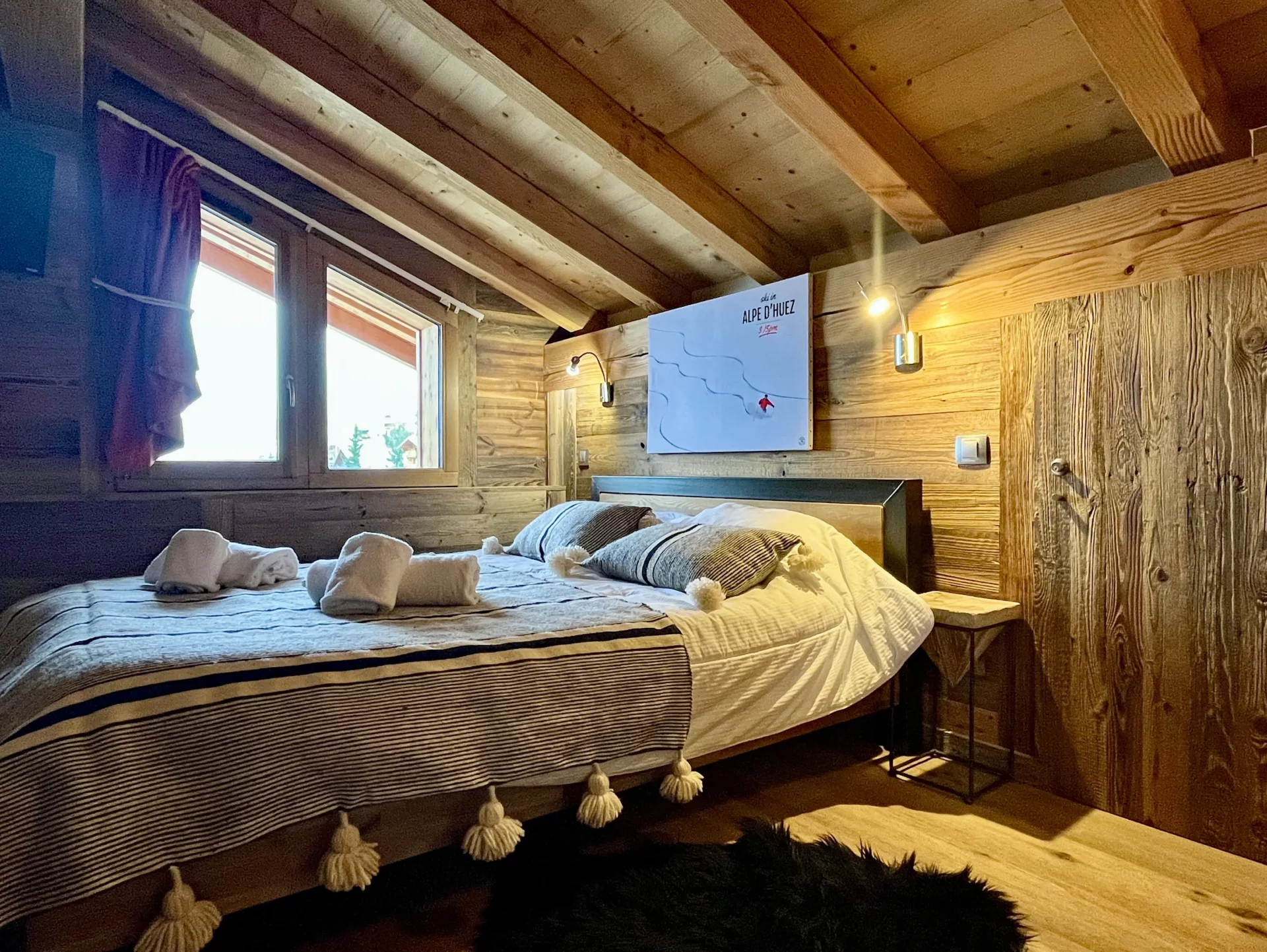 Découvrez cette élégante chambre double de notre location appartement Alpe d’Huez. Avec son bois chaleureux et son accès direct à la salle de bain, elle offre confort et authenticité pour un séjour à la montagne.