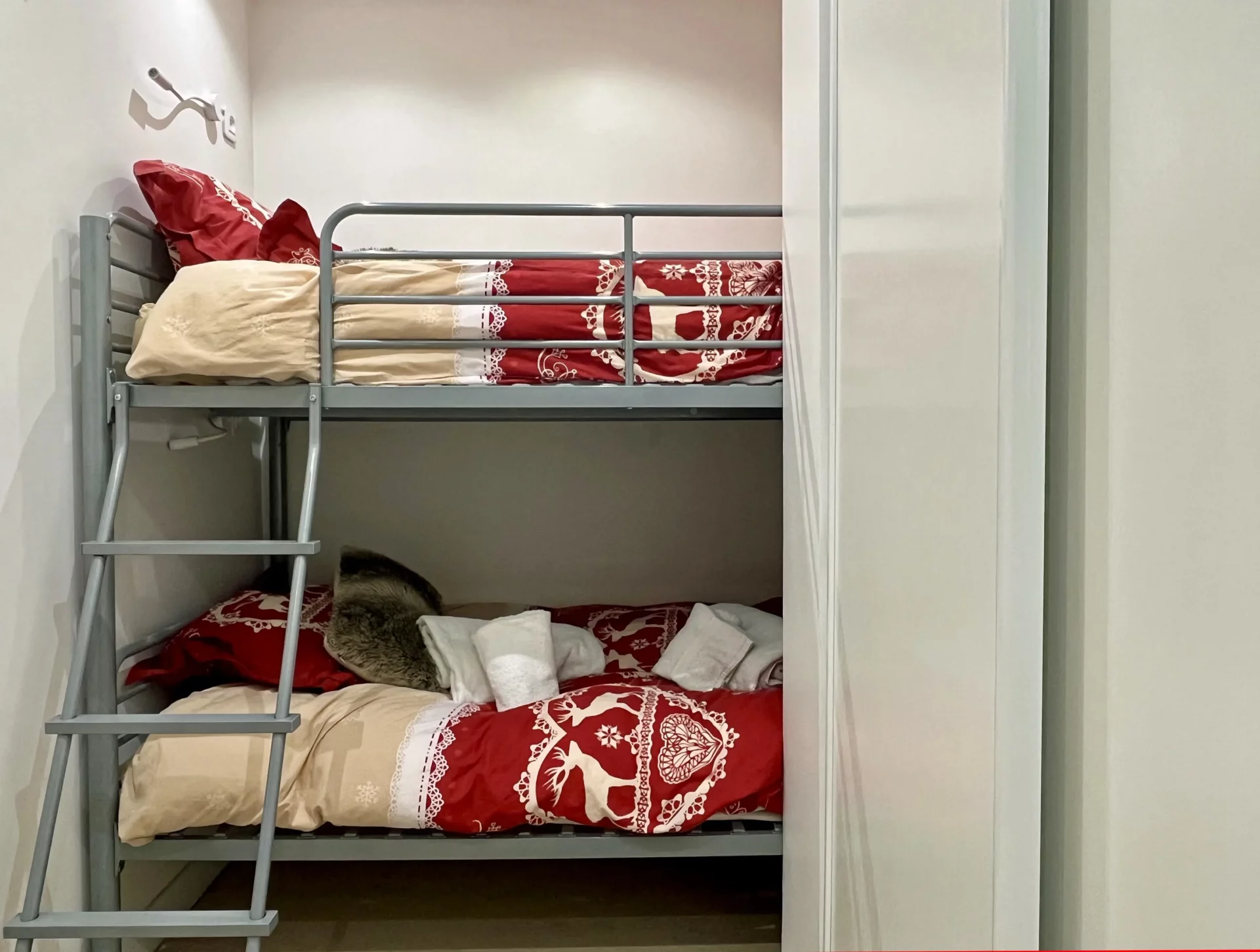 Vue rapprochée du coin montagne du Chalet Isba à l’Alpe d’Huez, lits superposés confortables et linge de lit montagnard.