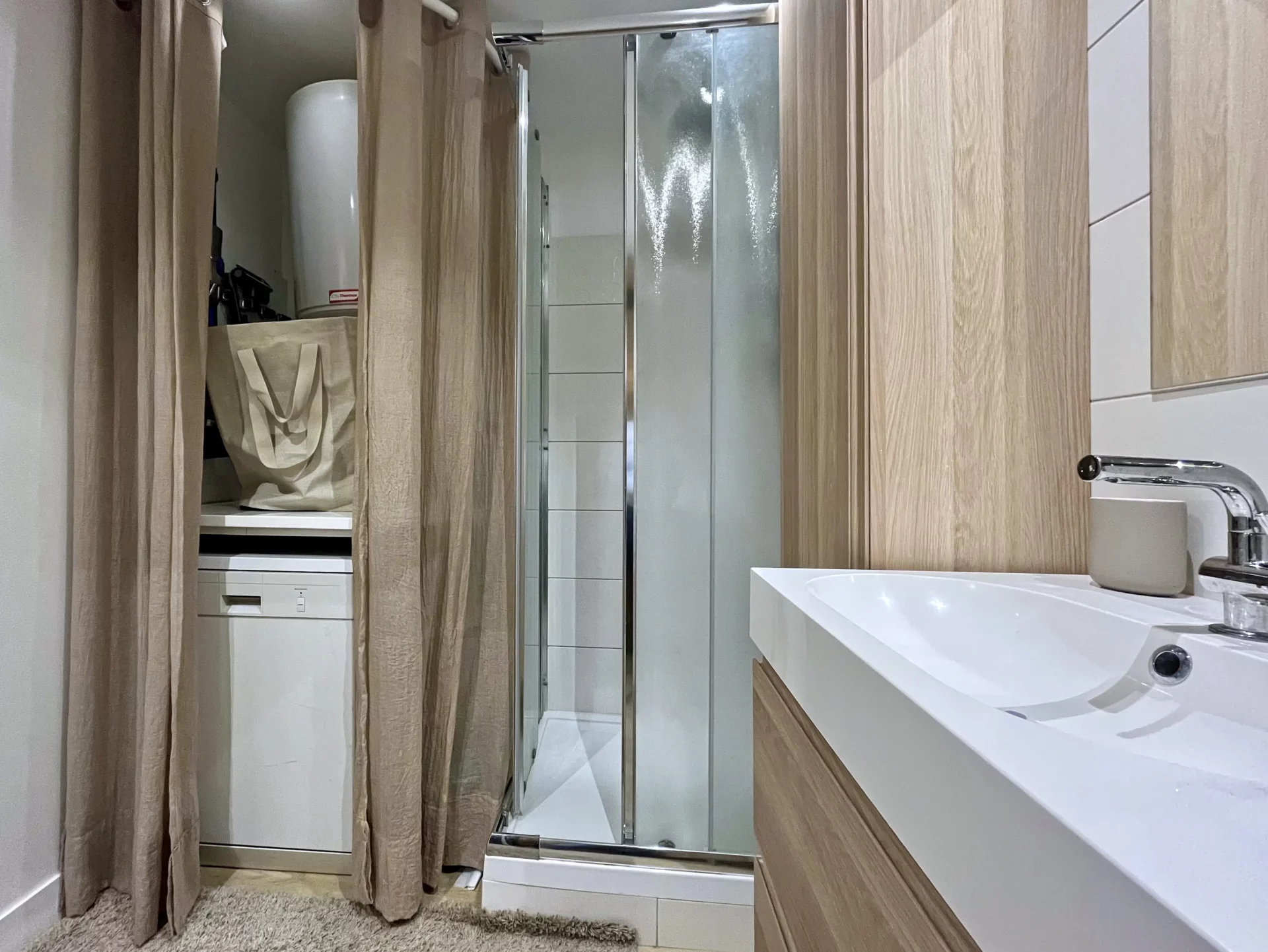 Vue intérieure de la salle de bain du Chalet Isba, avec porte coulissante en bois massif, sèche-serviettes mural et tapis moelleux au sol.