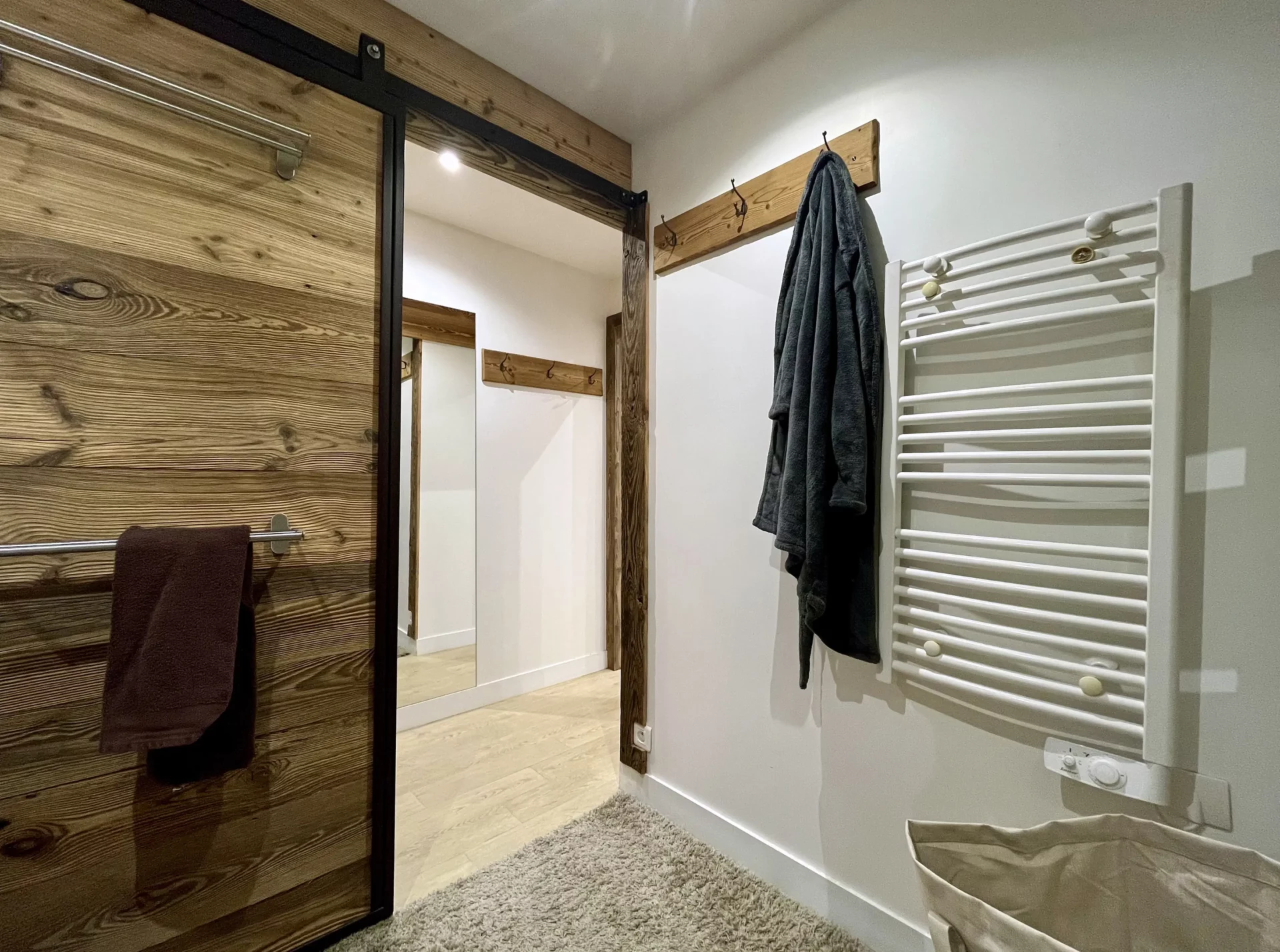 Salle de bain du Chalet Isba à l’Alpe d’Huez avec douche vitrée, meuble double vasque en bois clair