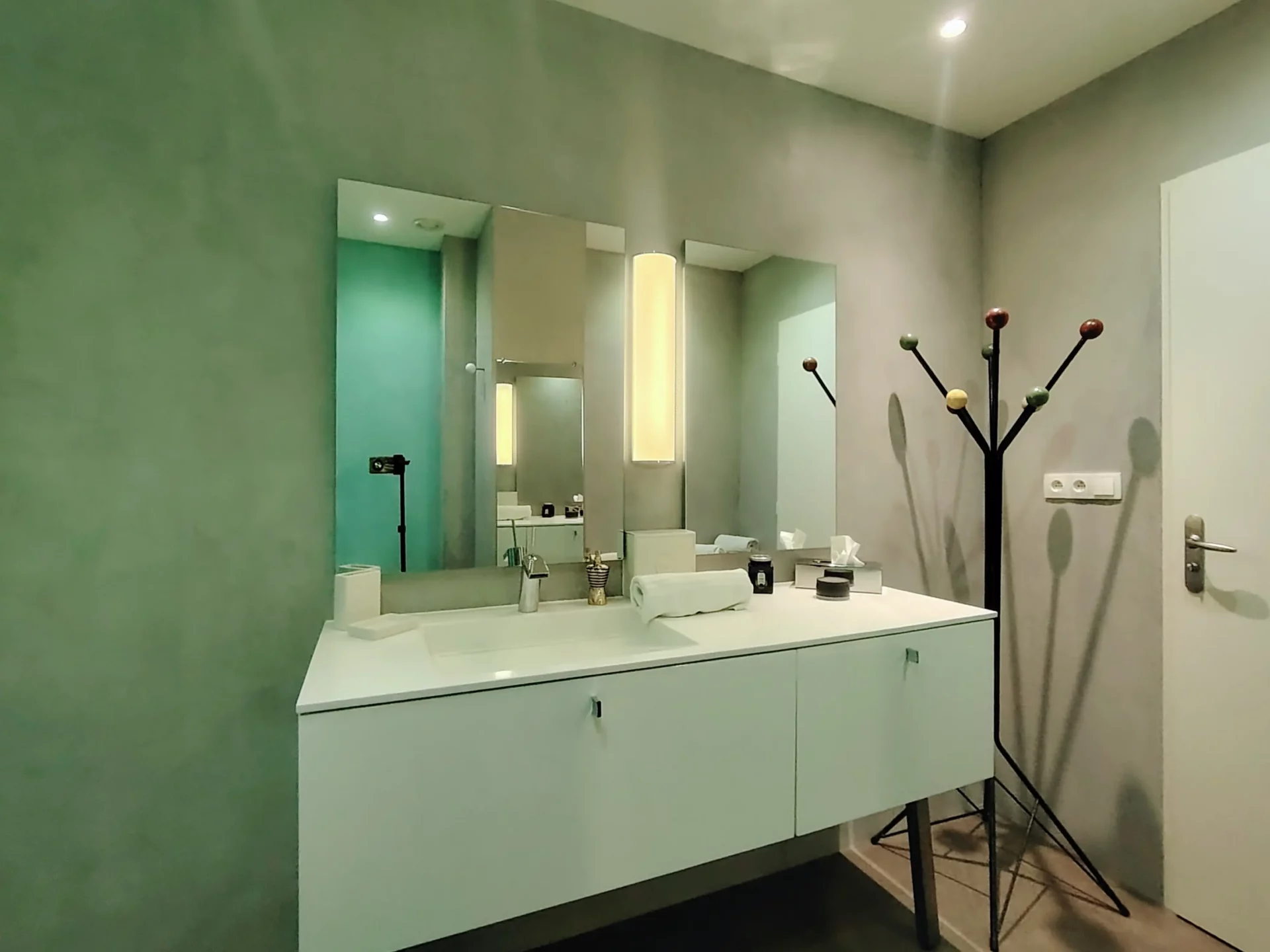 Vasque design avec grand miroir et éclairage moderne dans la salle de bain.