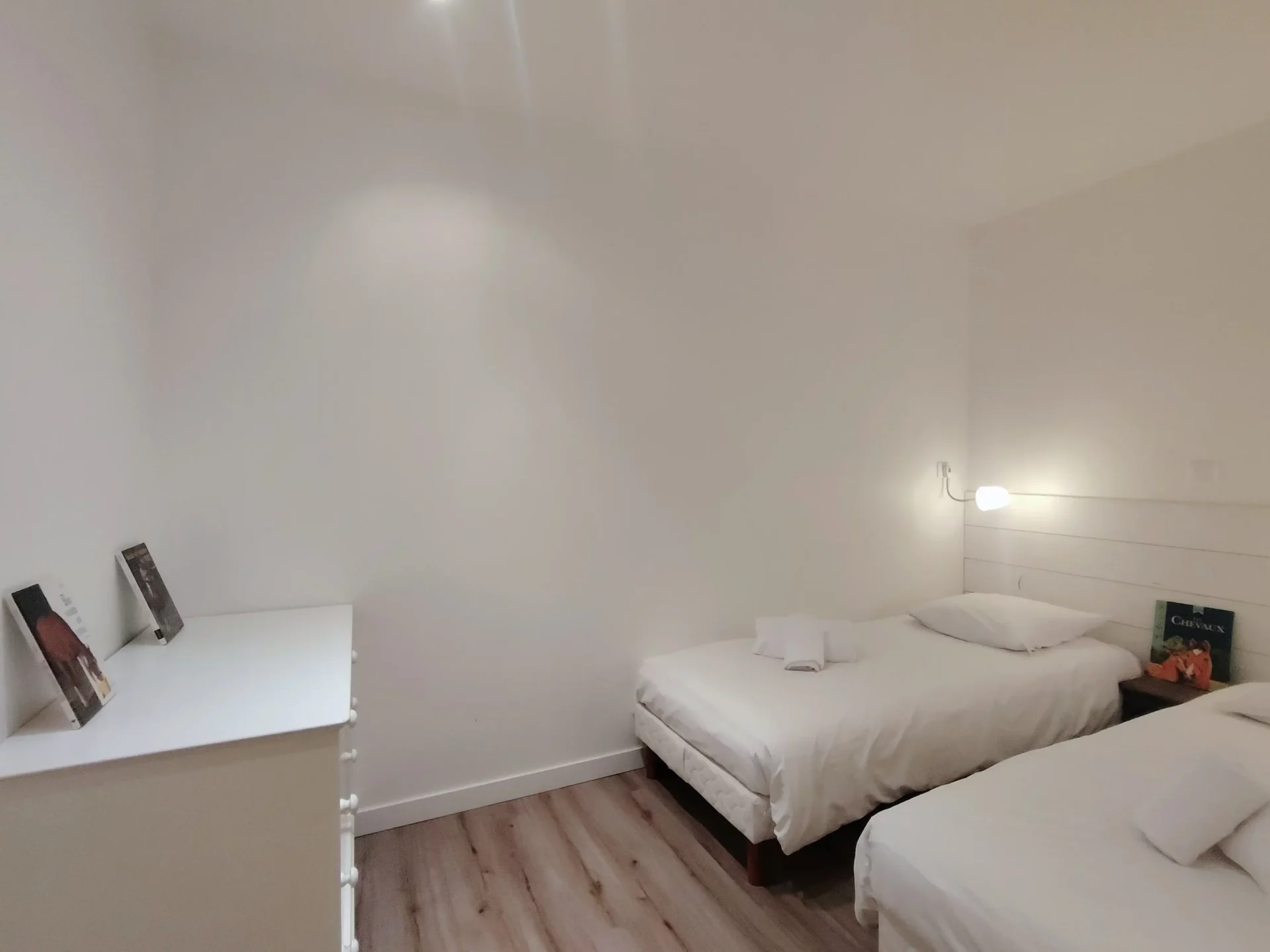 Chambre double lits simples avec commode blanche et ambiance cocooning – Location saisonnière Alpe d’Huez