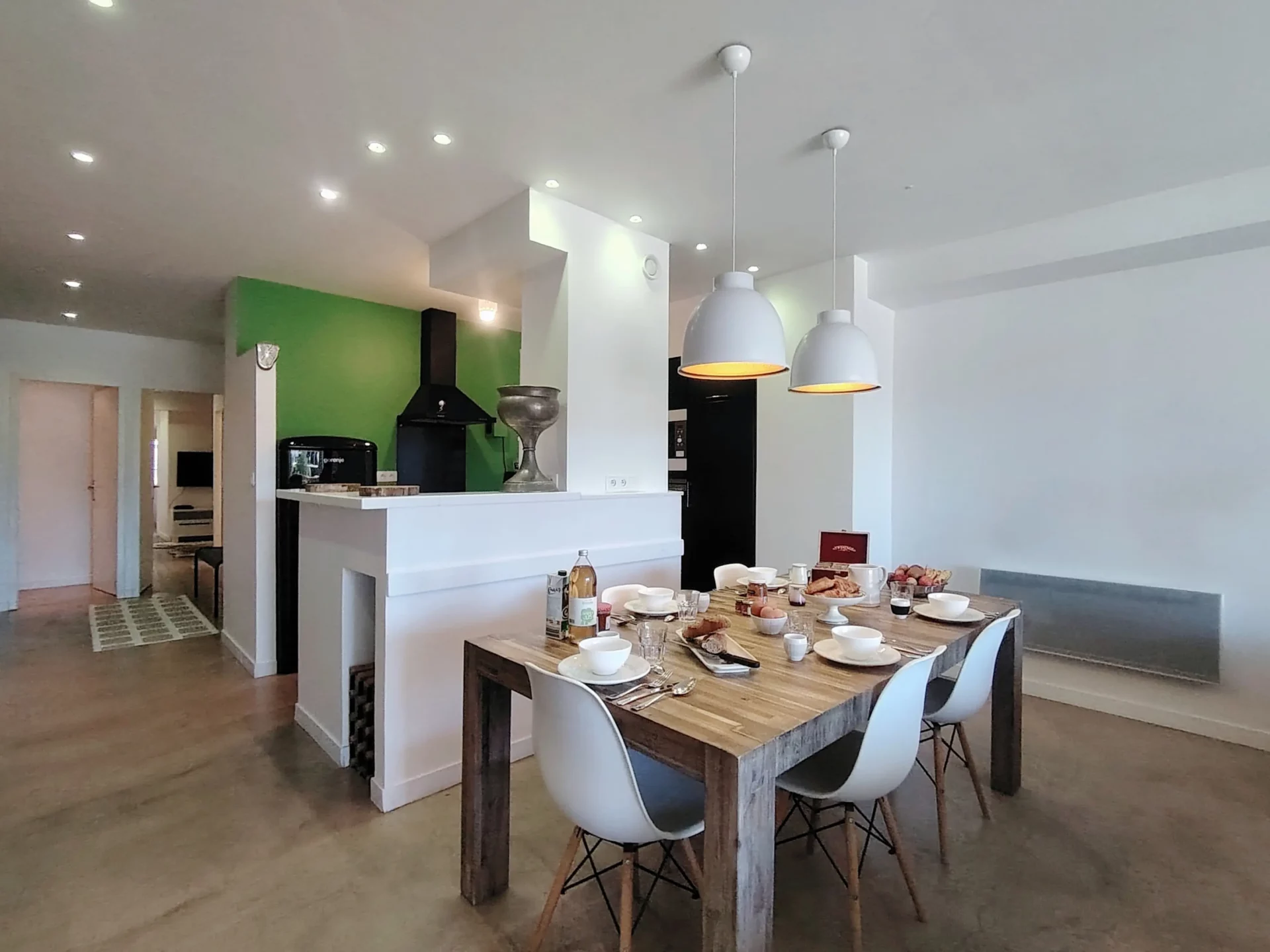 Salle à manger familiale avec grande table dressée et cuisine ouverte – appartement Alpe d’Huez