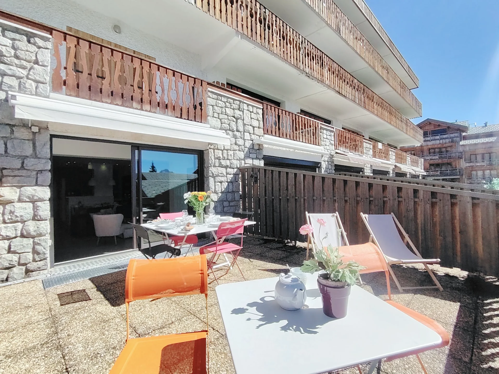 Coin repas extérieur sur la terrasse privative avec chaises longues, Résidence Ménandière Alpe d’Huez.