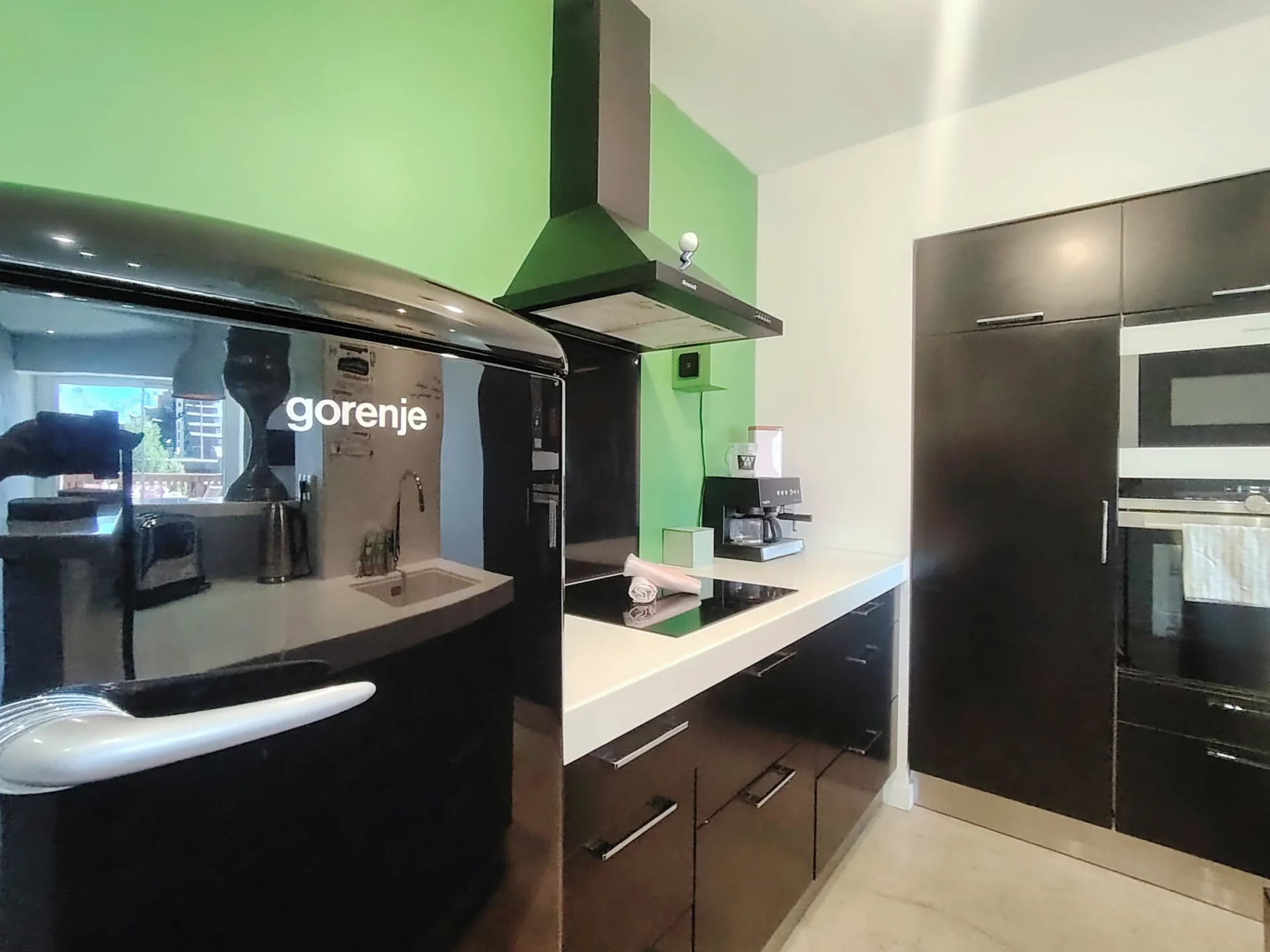 Cuisine équipée avec réfrigérateur noir gorenje, plaques à induction et cafetière – appartement Alpe d’Huez